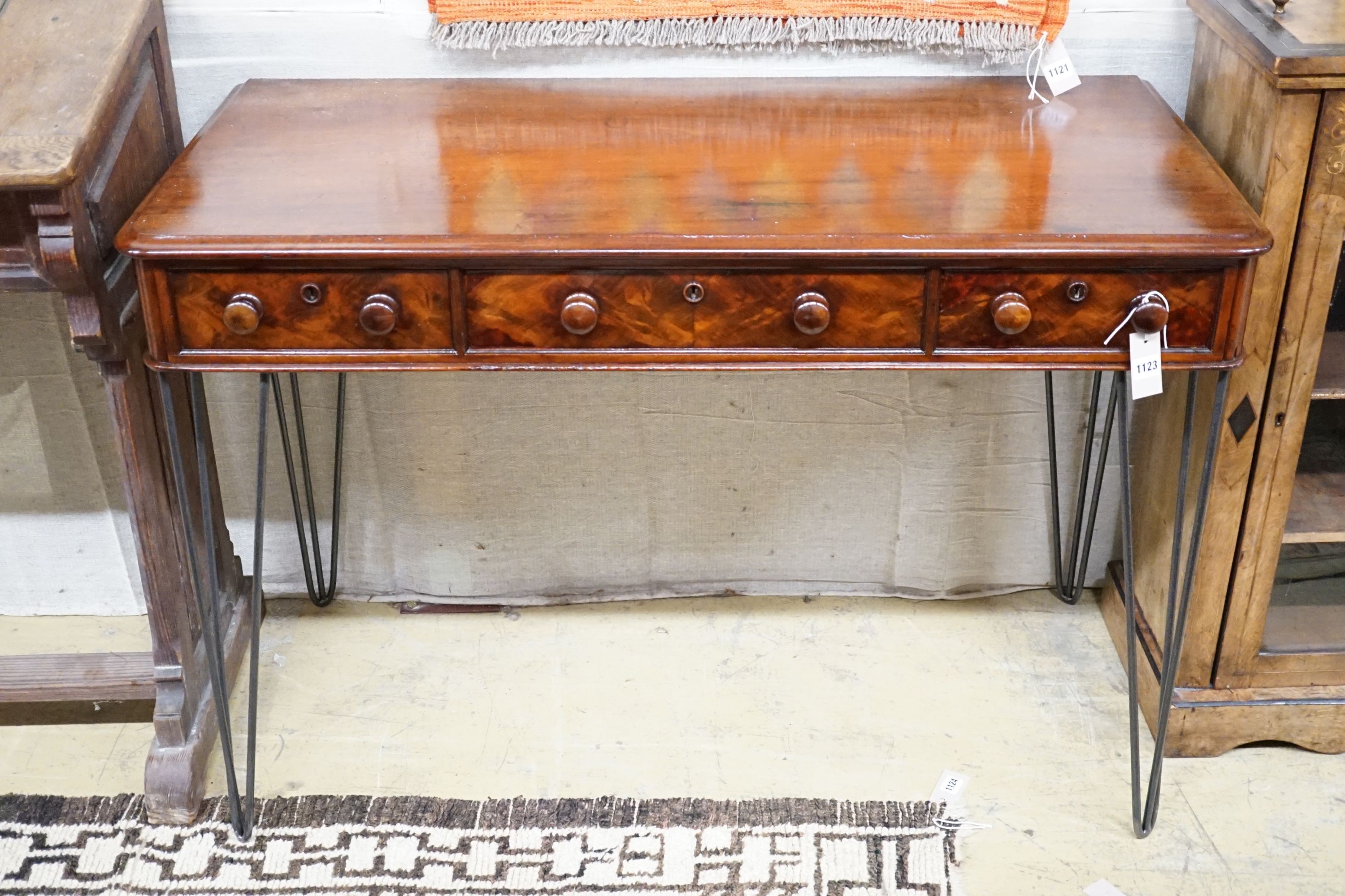 A Victorian mahogany writing table raised on later wrought iron legs, width 118cm, height 82cm
